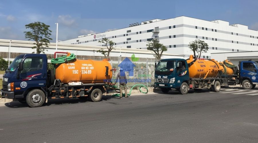 Đoàn xe hút bồn vàng đỗ trước tòa nhà lớn, dịch vụ hút hầm cầu quận Tân Phú